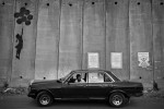 Ein palästinensischer Taxichauffeur wartet bei der Mauer in A-Ram auf Kundschaft, Westbank 2005  © Oded Balilty
